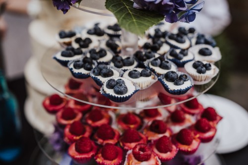 Eine Etagere mit Himbeerenmuffins und Blaubeerenmuffins.