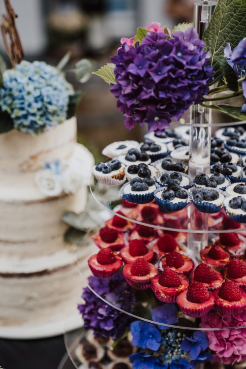 Eine Hochzeitstorte und eine Etagere mit Muffins.