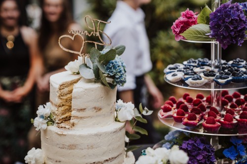 Eine Hochzeitstorte und eine Etagere mit Muffins.