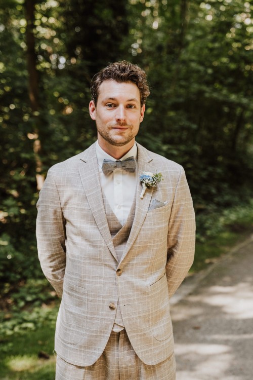 Ein Portrait von einem Bräutigam im Wald.