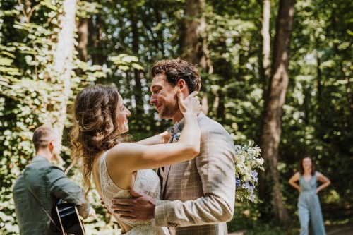 Ein Brautpaar umarmt sich mitten im Wald.