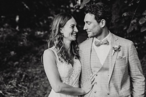 Ein schwarz-weißes Bild von einem Brautpaar im Wald.