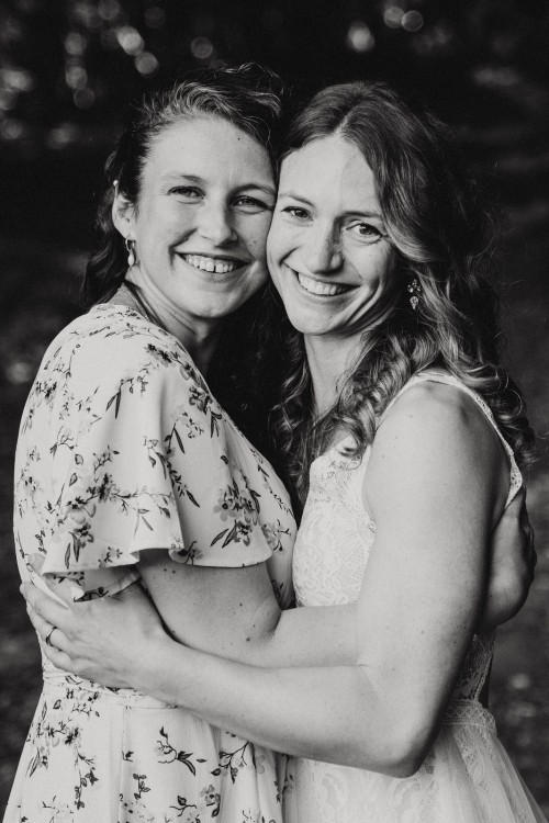 Zwei Frauen umarmen sich und posieren für ein Foto.