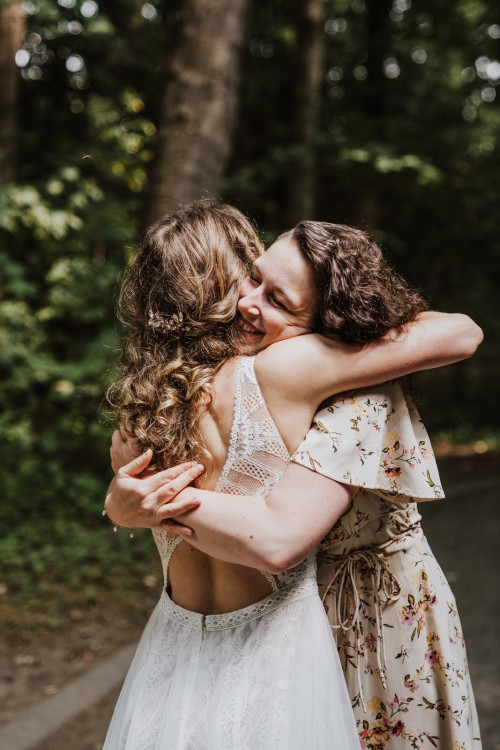 Eine Frau umarmt die Braut.