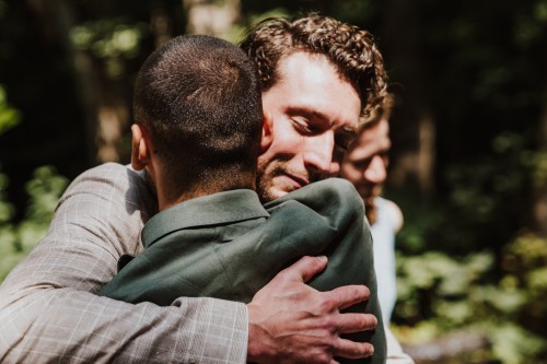 Ein Mann umarmt einen Bräutigam.