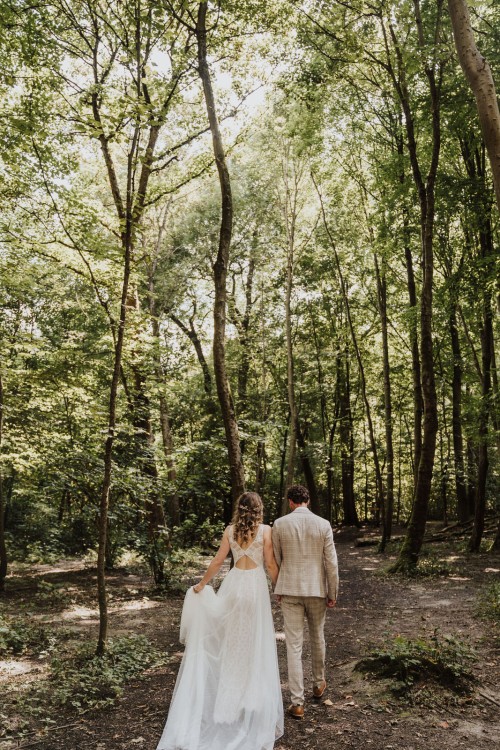 Ein Brautpaar spaziert durch einen Wald.