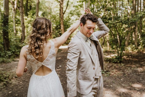 Eine Braut und ein Bräutigam tanzen mitten im Wald.