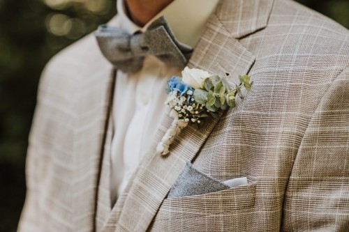 Ein Blumenanstecker am Sakko des Bräutigams.