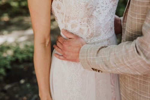 Ein Bräutigam umarmt eine Braut.