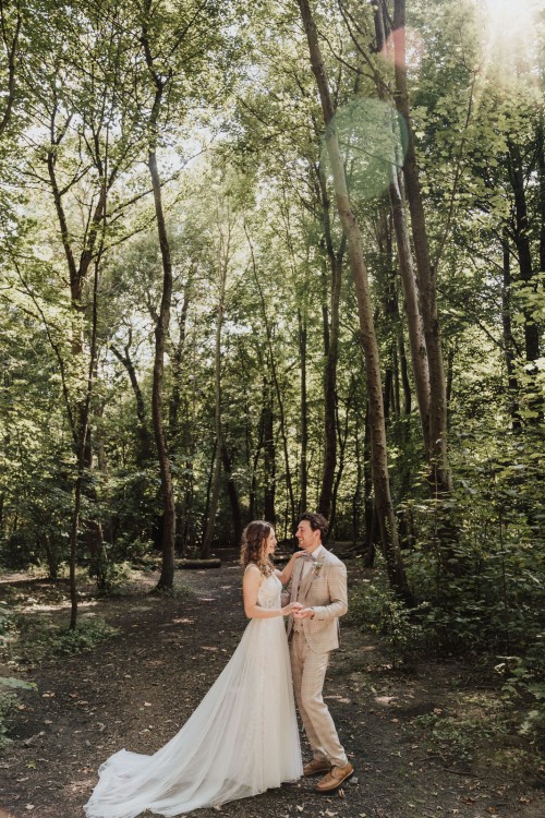 Ein Brautpaar umarmt sich mitten im Wald.