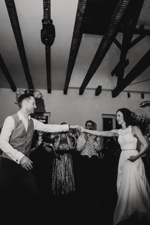 Ein Mann und eine Frau tanzen und eine Gruppe von Menschen schaut zu.