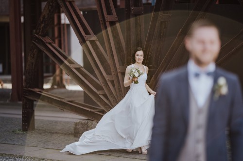 Eine Braut steht hinter einem Bräutigam.