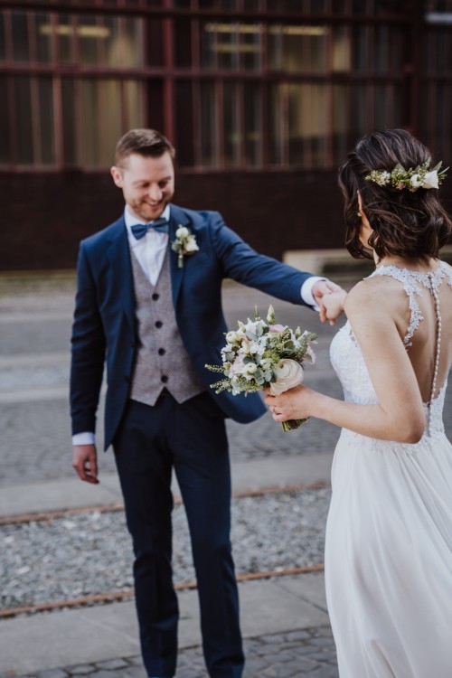 Ein Bräutigam hält die Hand der Braut.