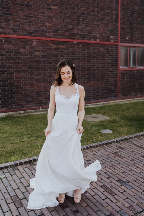 Eine Braut steht vor einem Gebäude.