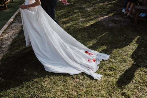 Die Schleppe einer Braut mit Rosenblüten drauf.
