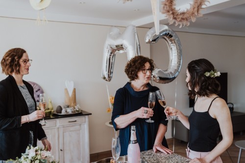 Drei Frauen stoßen mit Sekt an.