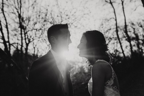 Ein schwarz-weißes Bild von einem Brautpaar im Wald.