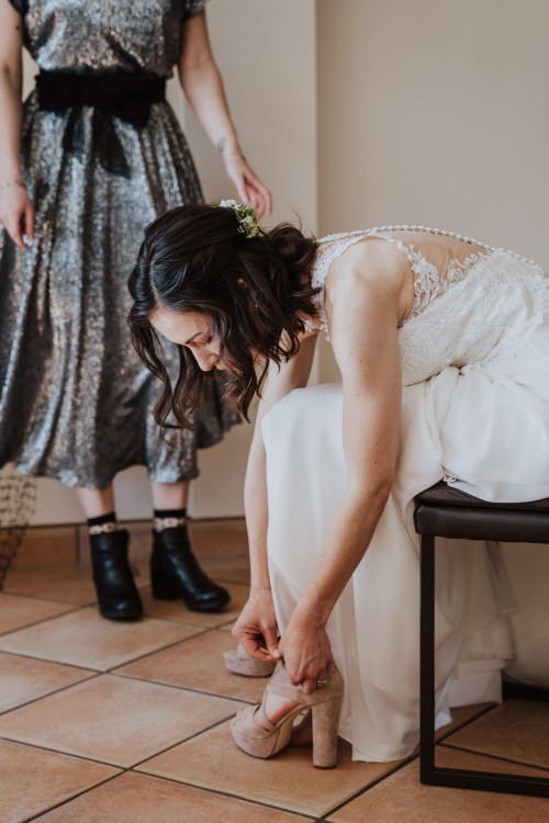 Eine Braut zieht sich ihre Schuhe an.