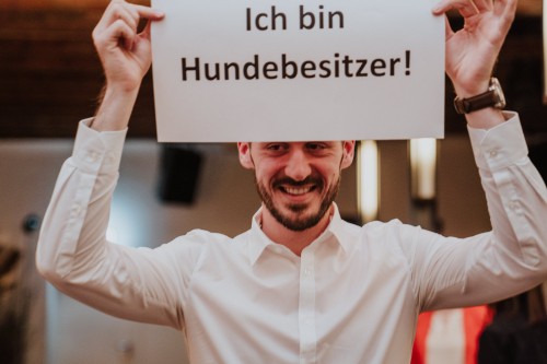 Ein Mann hält ein Schild hoch.