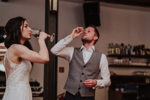 Eine Braut und ein Bräutigam trinken Wein.