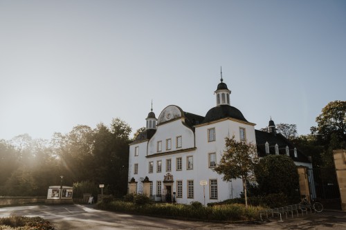 Ein Gebäude umschlossen von Bäumen.