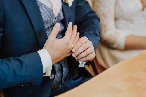 Ein Bräutigam richtet seinen Ehering an seiner Hand.