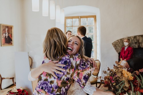 Eine Braut wird von einer Frau umarmt.