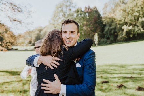 Eine Frau umarmt einen Bräutigam.