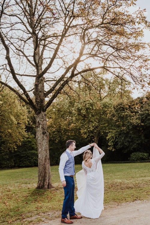 Ein Brautpaar tanzt im Park.