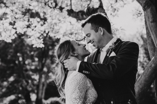 Ein schwarz-weißes Bild von einem Brautpaar welches sich anschaut.