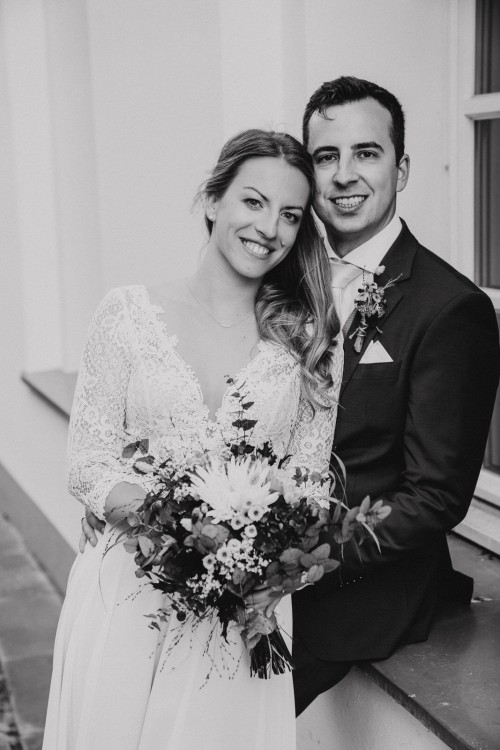 Ein schwarz-weißes Bild von einem umarmten Brautpaar.