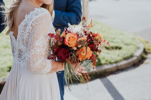 Eine Braut hält einen bunter Brautstrauß in der Hand.