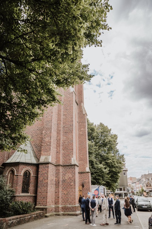 Eine Gruppe von Menschen steht vor einer Kirche.