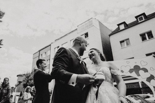 Eine Braut und ein Bräutigam stehen nebeneinander auf der Straße.