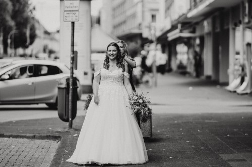 Ein schwarz-weißes Bild von einer Braut und einer Frau die der Braut die Haare richtet.