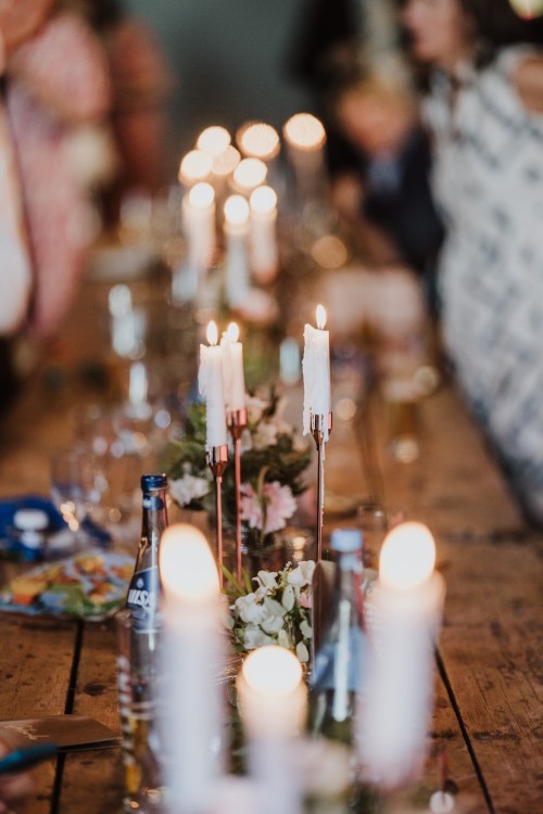 Ein festlich gedeckter Tisch mit angezündeten Kerzen.