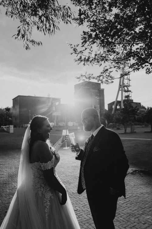 Ein Brautpaar stoßt an auf einem Zechegelende.