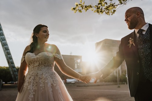 Eine Braut und ein Bräutigam halten Händchen.