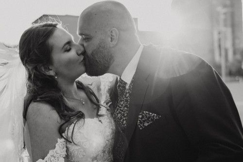 Ein schwarz-weißes Bild von einem küssenden Brautpaar.