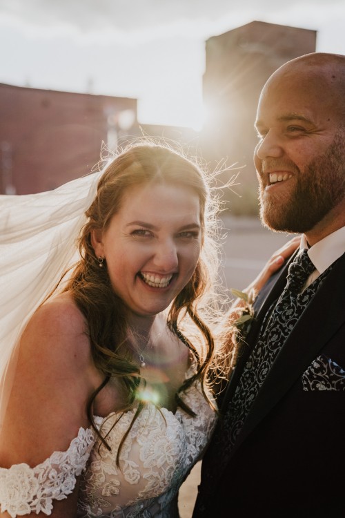 Ein Brautpaar steht im Sonnenuntergangslicht.