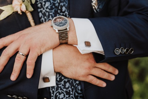 Die Hände des Bräutigams mit einer Uhr und Manschettenknöpfen.