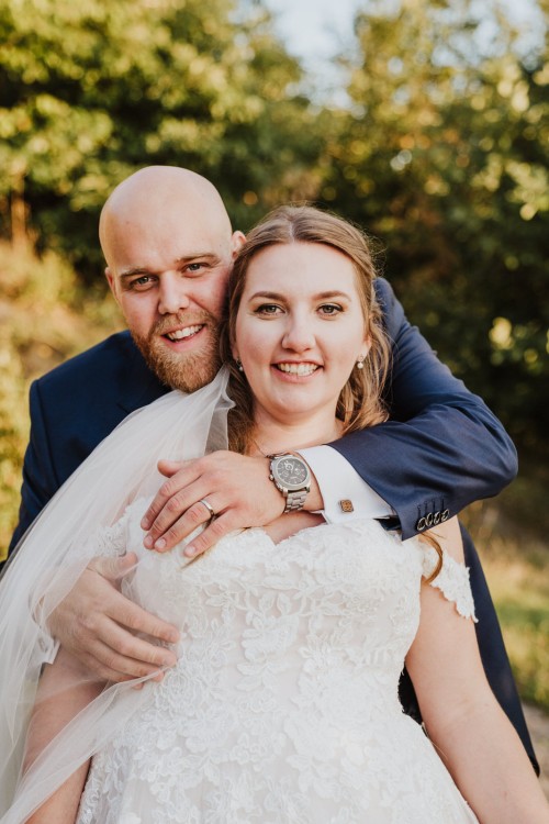 Ein Bräutigam umarmt eine Braut.