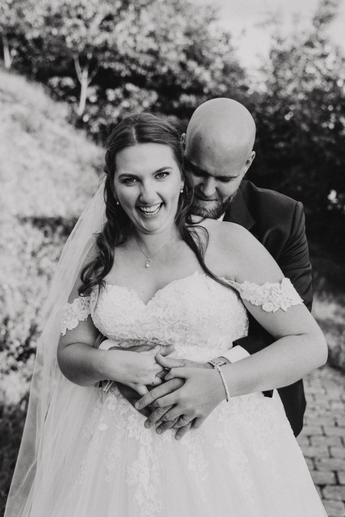 Ein Bräutigam umarmt eine Braut.