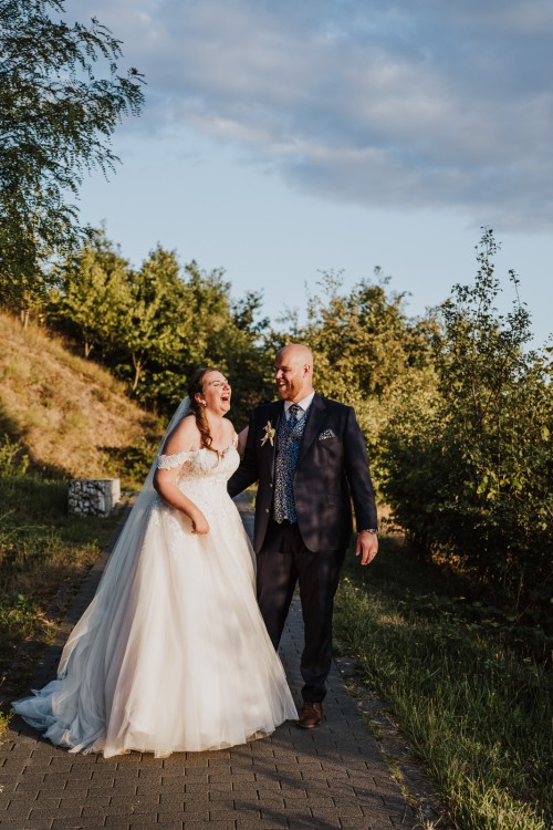 Ein Brautpaar spaziert in einem Park.