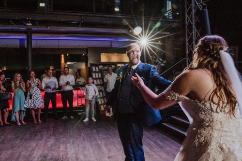 Ein Brautpaar tanzt auf der Tanzfläche und die Gäste schauen zu.