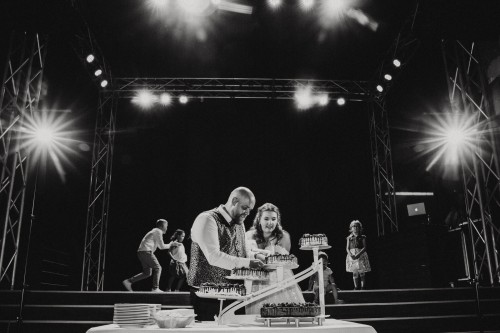 Ein Brautpaar schneidet eine Hochzeitstorte an.