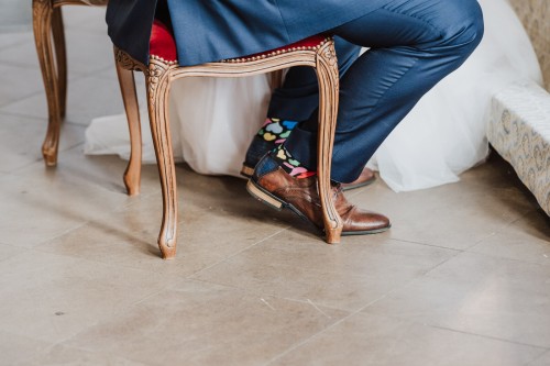 Ein Mann sitzt auf einem Stuhl und trägt bunte Socken.