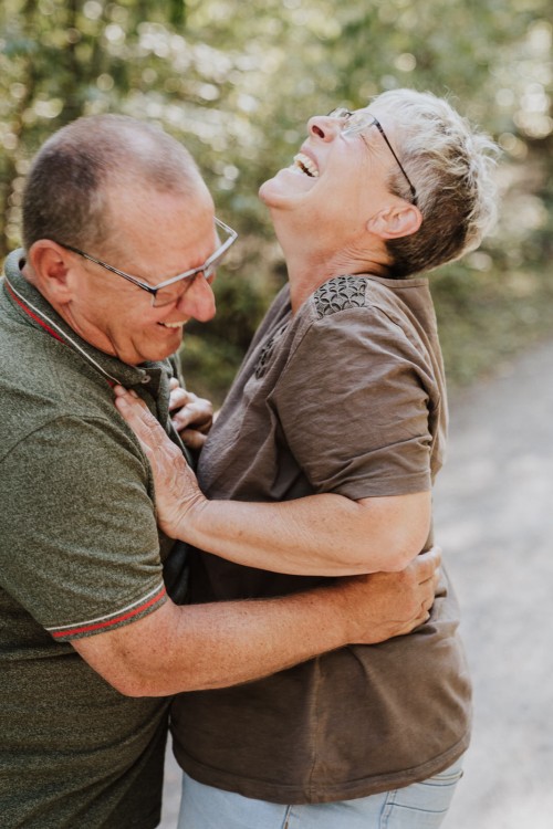 Opa kitzelt die Oma, die sehr fröhlich lacht.