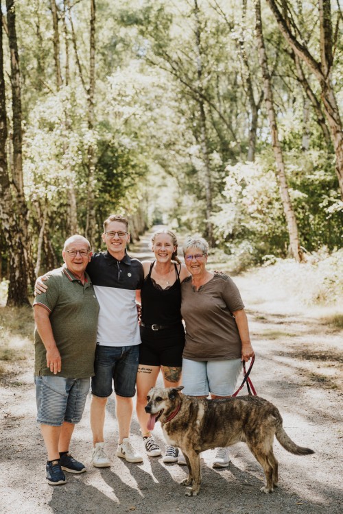 Ein Familienfoto von den Großeltern und den Eltern zusammen mit dem Hund.