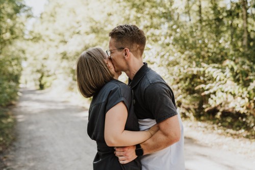 Ein Mann gibt einer Frau ein Kuss auf die Wange.